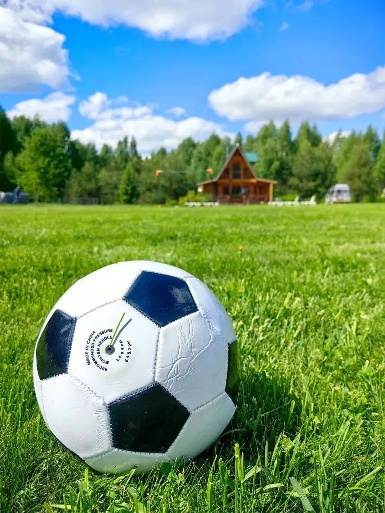 Мяч на лужайке рядом с детской площадкой
